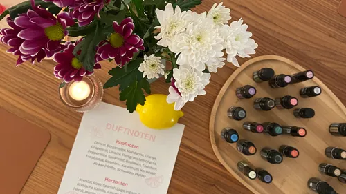 Blumen, Kerze, Öle, Liste auf Holztisch.