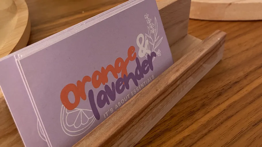 Visitenkarten in einem Holzhalter auf Tisch.