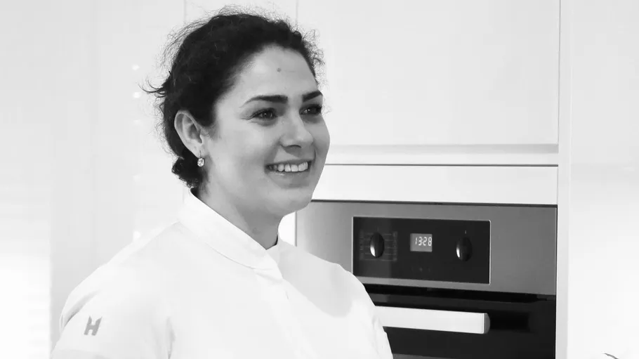 Smiling woman in kitchen with oven.