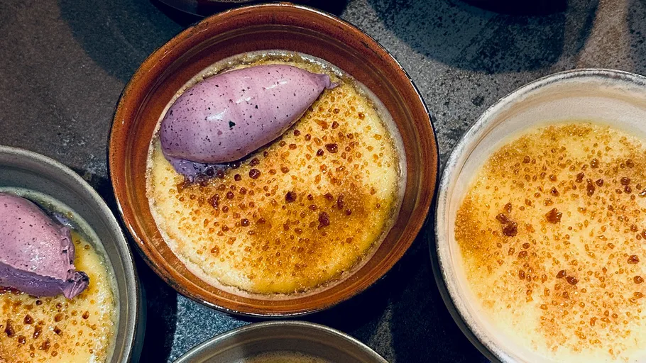 Schalen mit Crème brûlée und lila Eis.