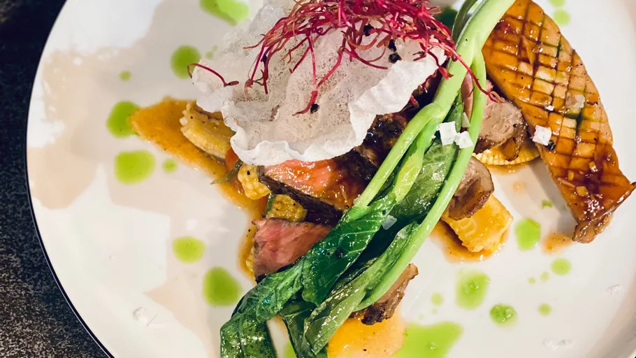 Gourmetgericht mit Gemüse und Sauce, elegant angerichtet.