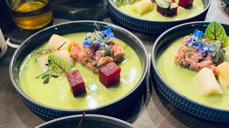 Gourmetgerichte mit grüner Soße und Garnierung.