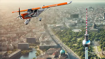 Small plane flying over Berlin skyline.