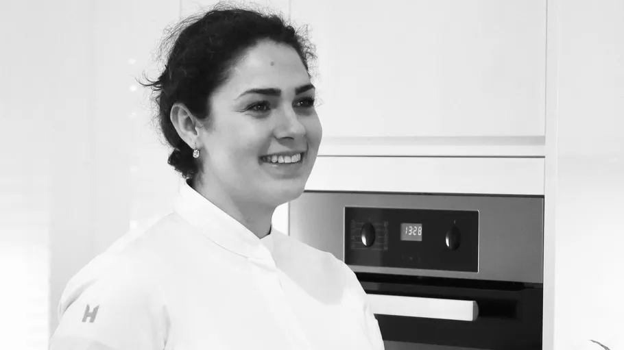 Woman smiling in kitchen near oven.