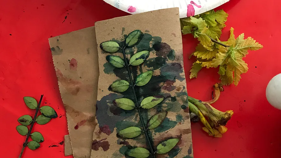 Leaves inked, pressed on cardboard, red background.