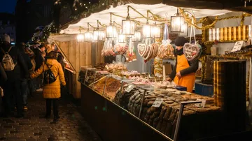 Verkäufer verkauft Leckereien am festlichen Marktstand.
