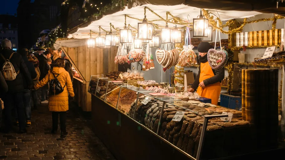 Vendor selling treats at festive market stall.