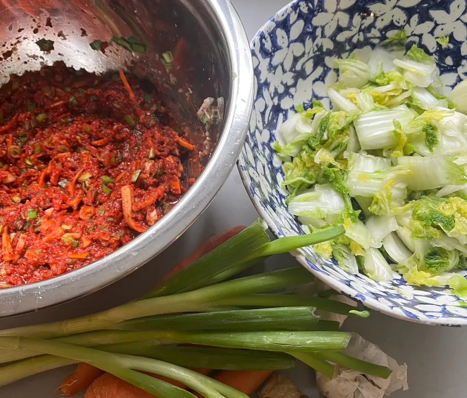 Kimchi-Zutaten in Schüsseln auf einem Tisch vorbereitet.