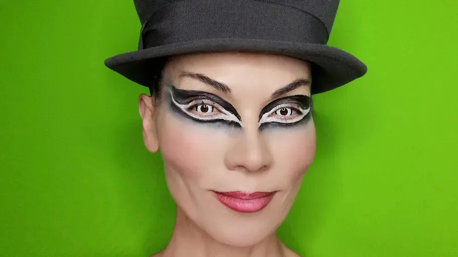 Person mit dramatischem Make-up, trägt Zylinderhut.