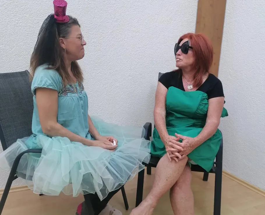 Zwei Frauen sitzen und unterhalten sich drinnen.