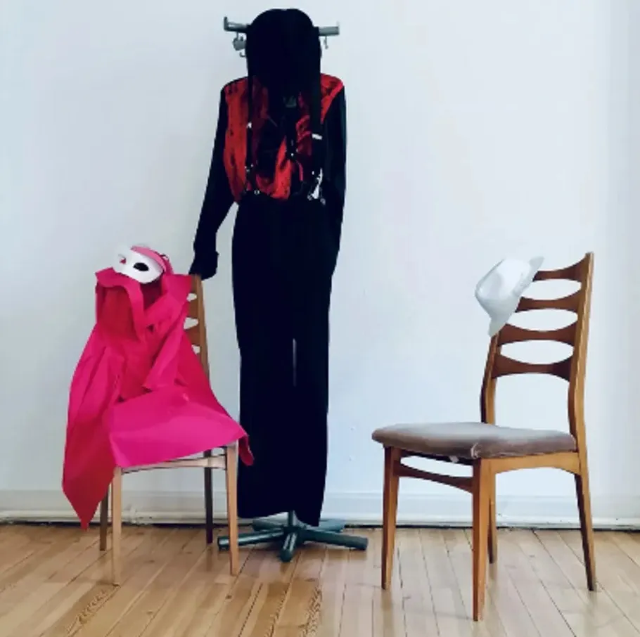 Clothes stand with two chairs in room.