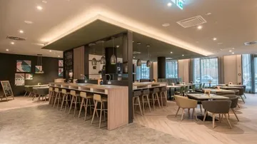 Modernes Restaurant mit Holzmöbeln und Beleuchtung.