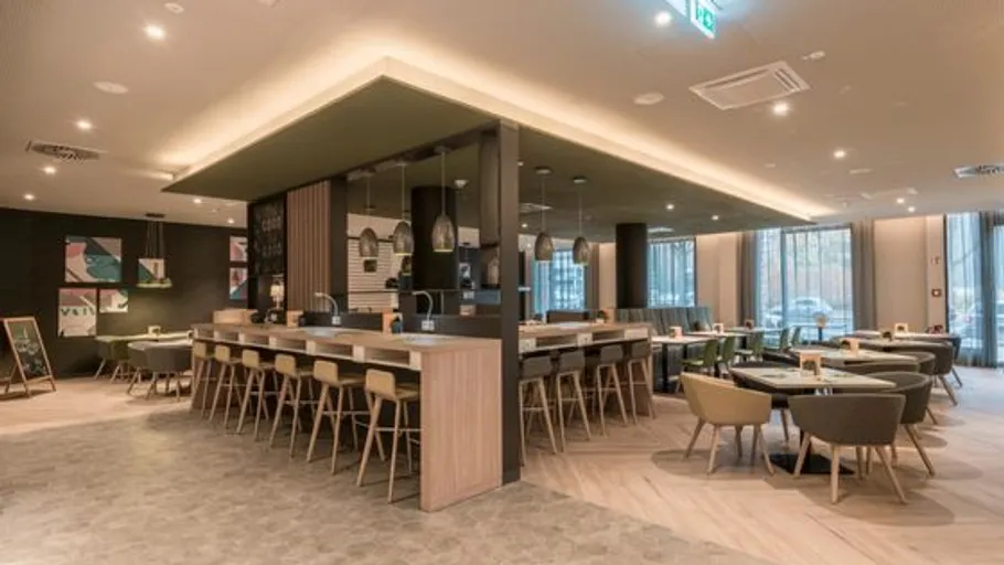 Modernes Restaurant mit Holzmöbeln und Beleuchtung.