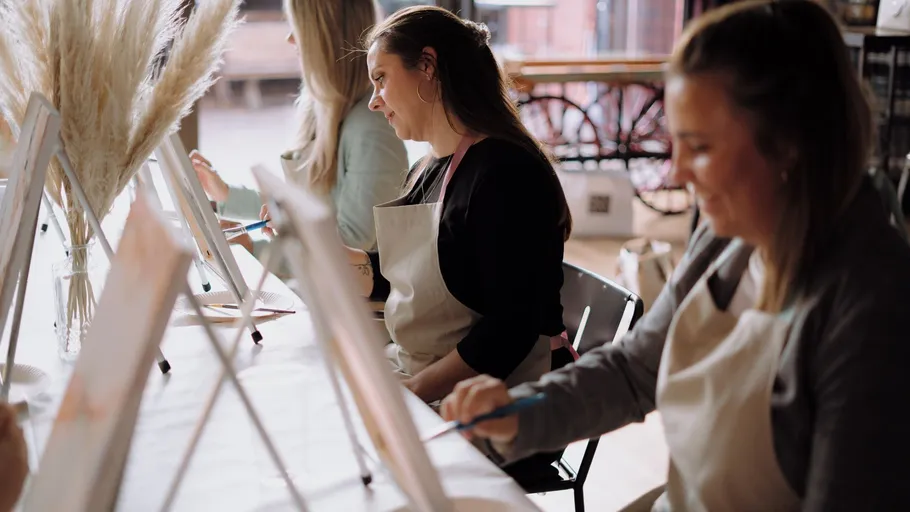 Frauen malen auf Leinwänden in einem Studio.