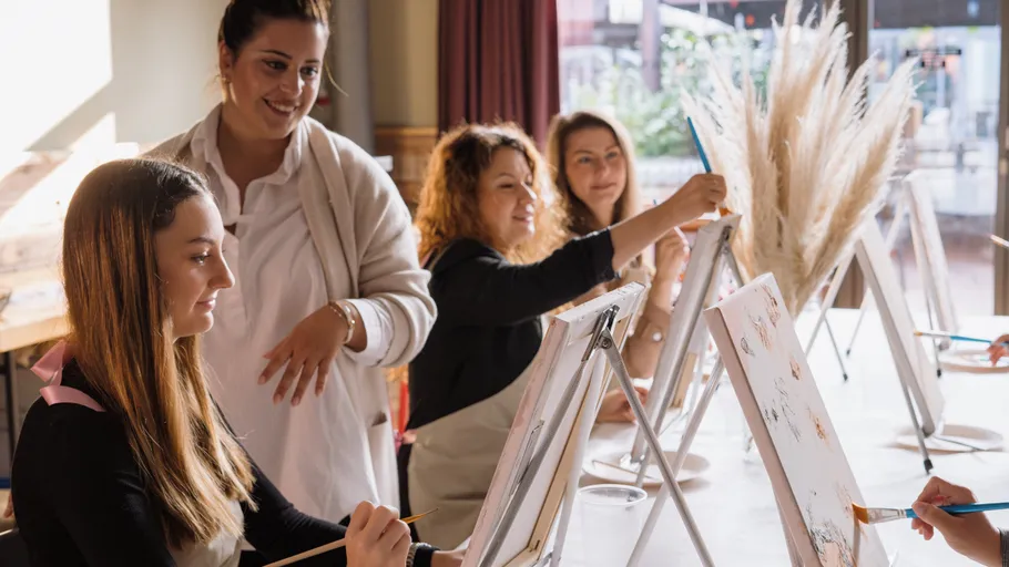 Frauen malen in einem Kreativworkshop drinnen.