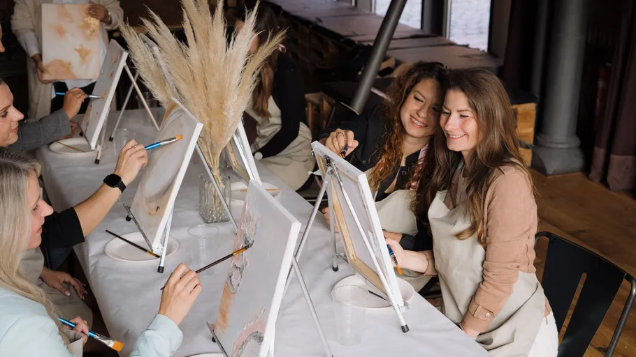 People painting on canvases at a workshop.