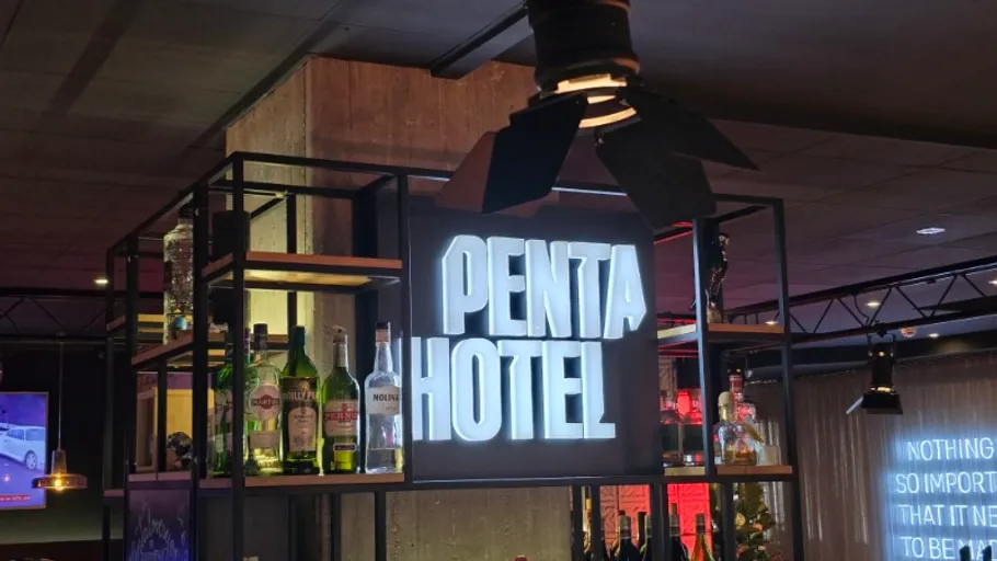 Barbereich mit beleuchtetem Penta Hotel Schild.