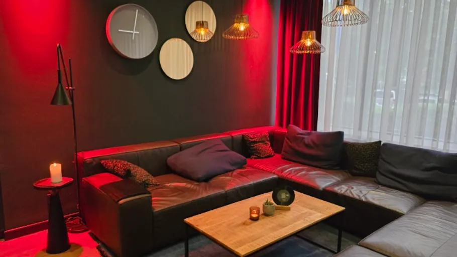 Gemütliches Wohnzimmer mit rotem Licht, Ledersofa.