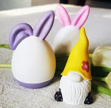 Easter eggs and gnome on table with flowers.