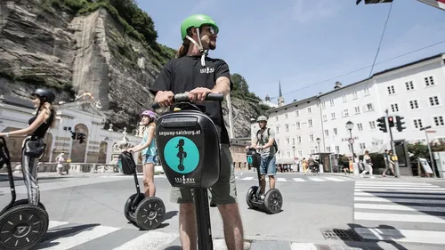 Personen fahren Segways in urbanem Salzburg.