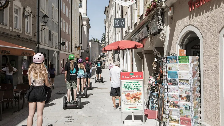 People riding Segways on a narrow street.