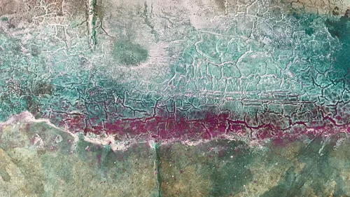 Cracked wall with green-blue and purple texture.