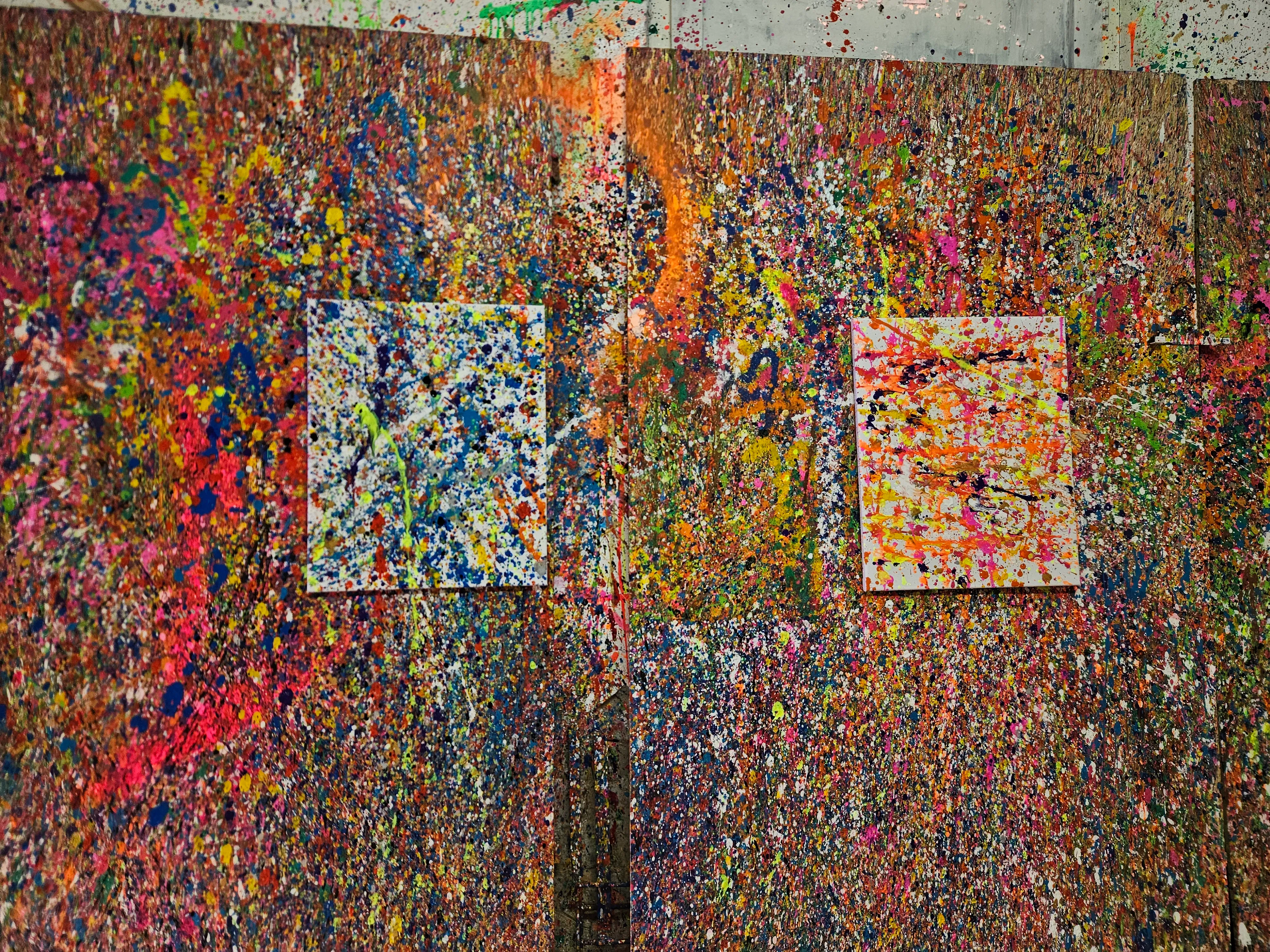 Colorful splatter paintings on textured walls.