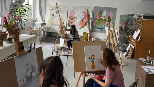 Artists painting in a bright studio.