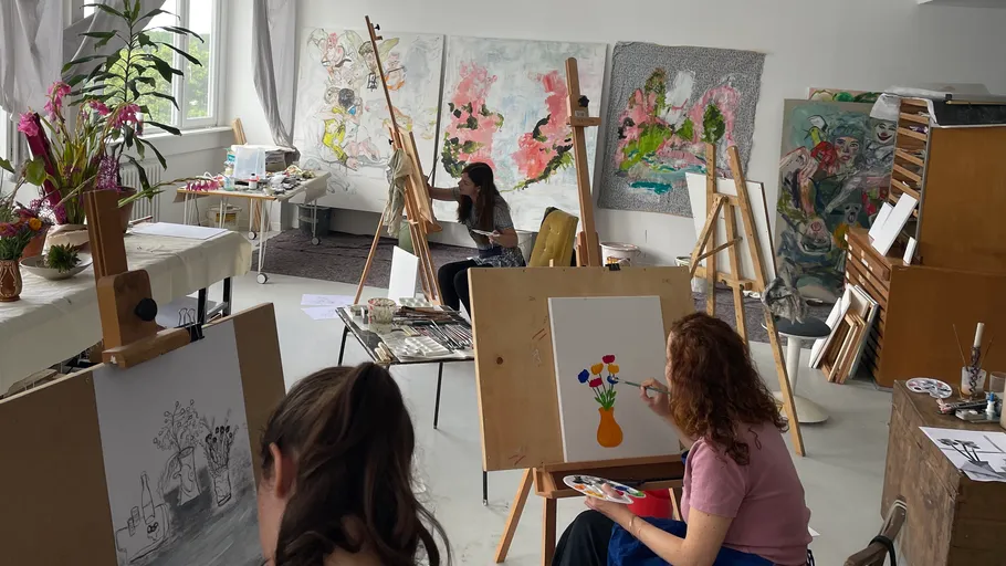 Artists painting in a bright studio.