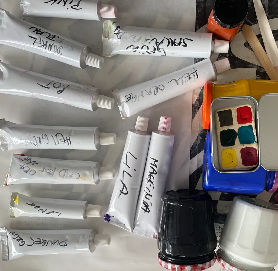 Various paint tubes scattered on a surface.