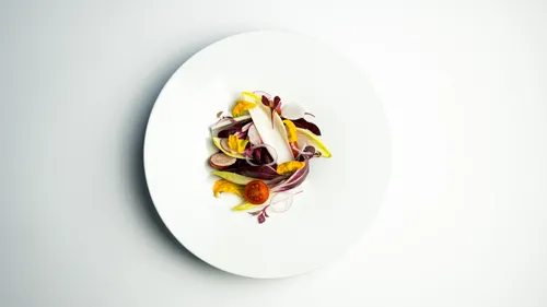 Salat mit Gemüse auf weißem Teller.