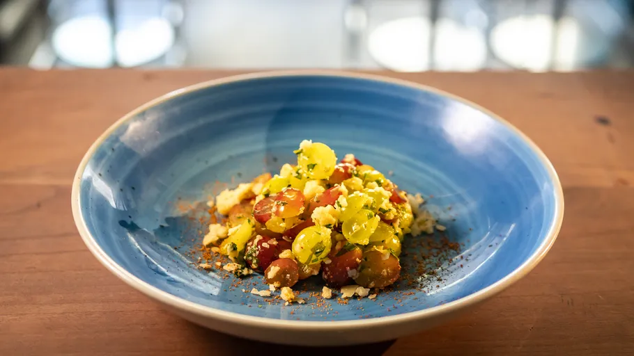 Bunter Tomatensalat in einer blauen Schüssel.
