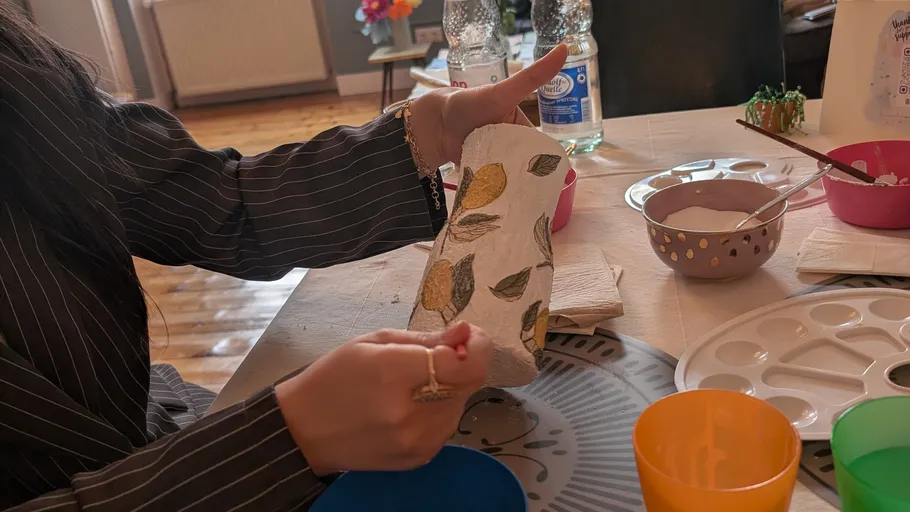 Person dekoriert Vase mit Zitronenmotiv.