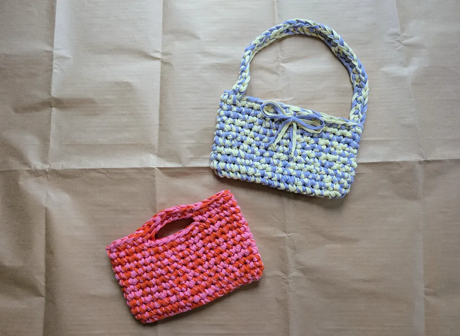 Two crocheted bags on brown paper background.