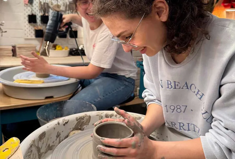 Two women making pottery in a studio.