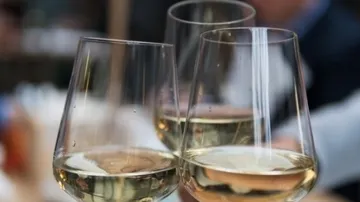 Three wine glasses toasting in a restaurant.