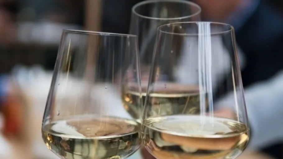 Three wine glasses toasting in a restaurant.