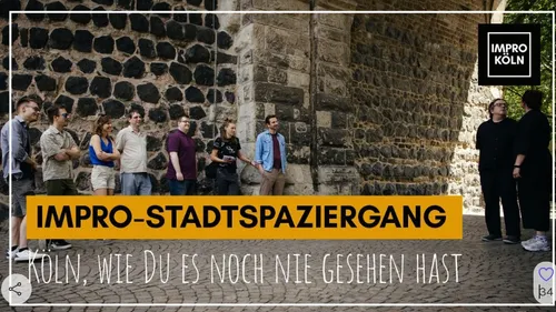 Gruppe steht im Freien an Steinmauer.