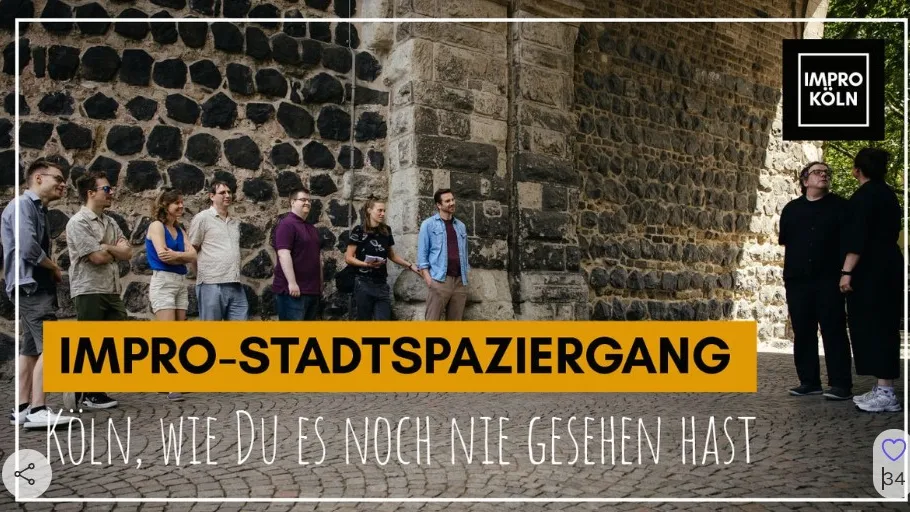 Gruppe steht im Freien an Steinmauer.
