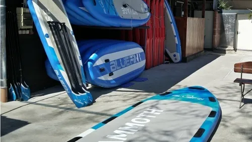 Paddleboards im Freien gestapelt unter Sonnenlicht.