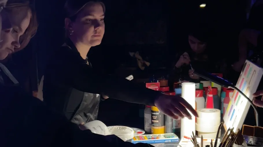 Person zeigt auf Make-up in schwach beleuchtetem Raum.