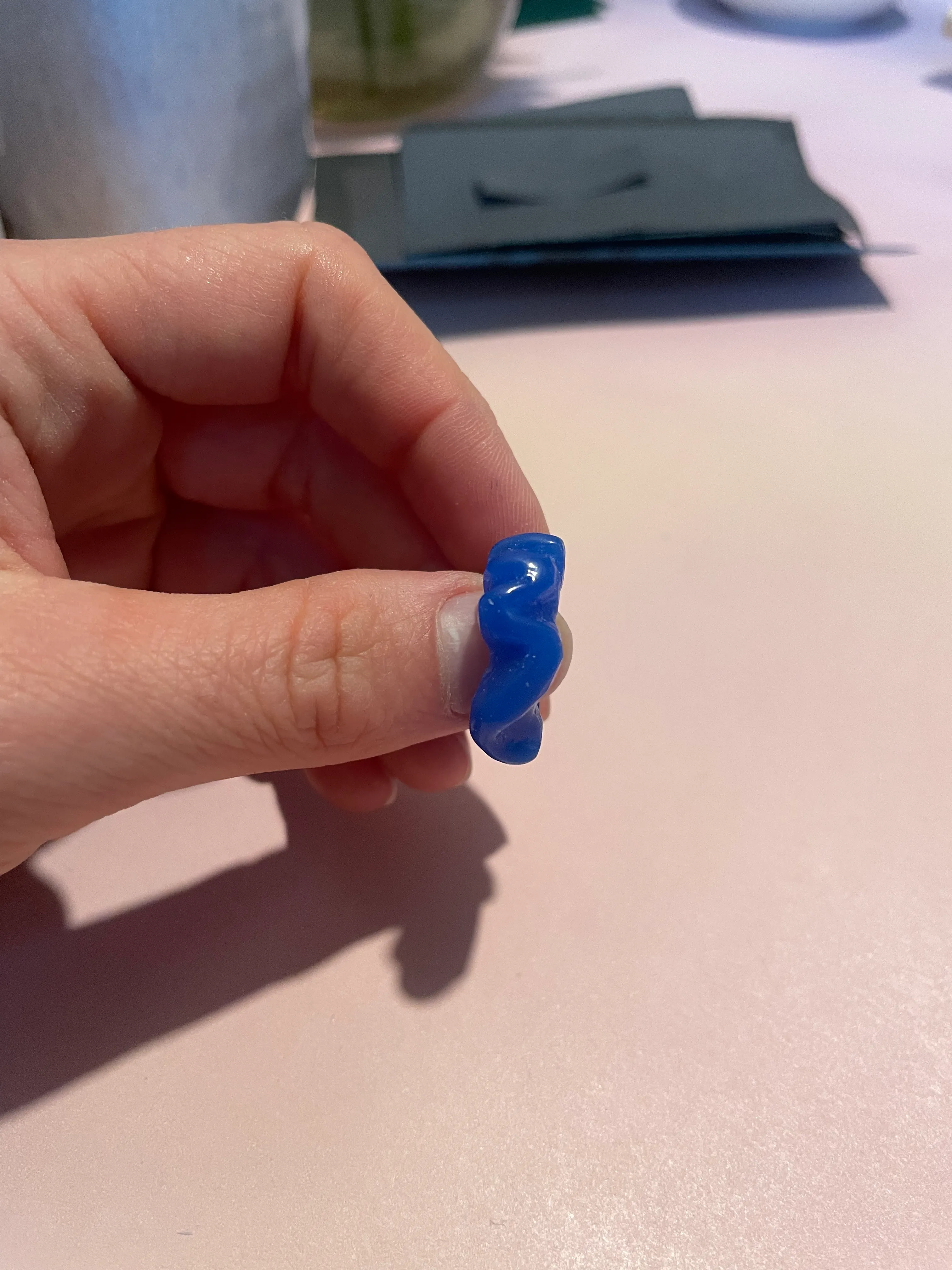 Hand hält blaues Gummibonbon drinnen.