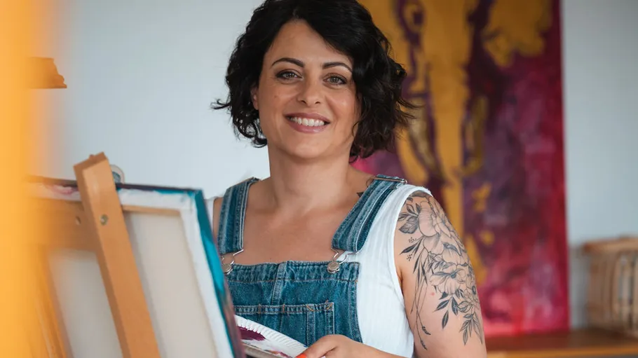 Woman smiling while painting in art studio.