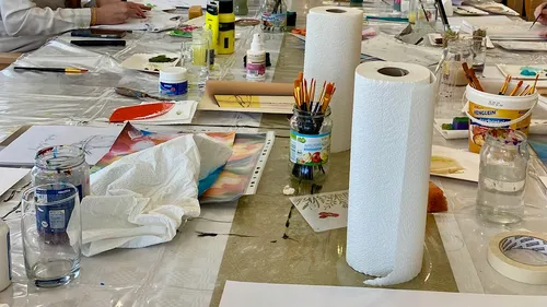Kunstzubehör auf einem Tisch während eines Workshops.
