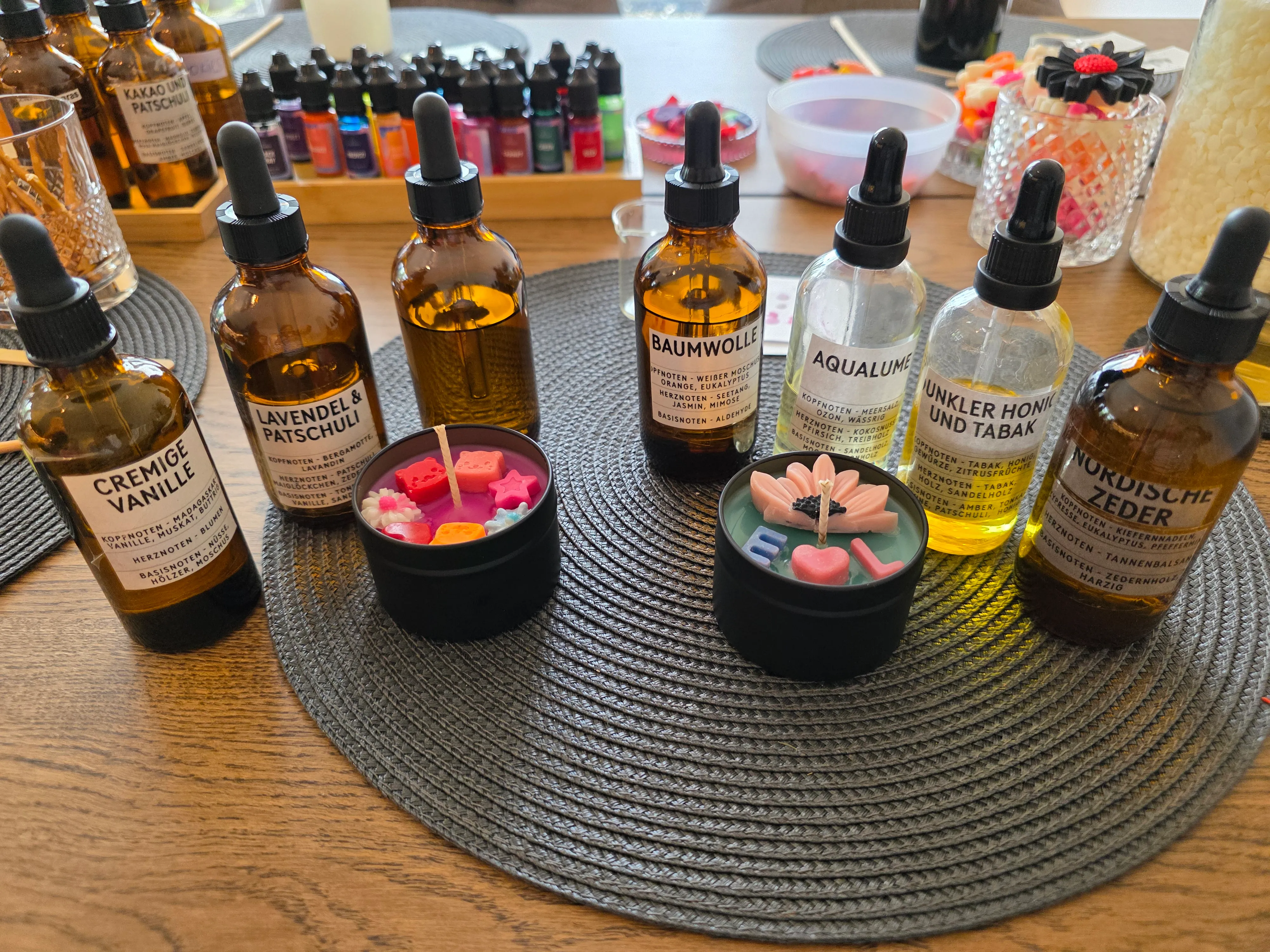 Aromatherapie-Flaschen und dekorierte Kerzen auf Tisch.