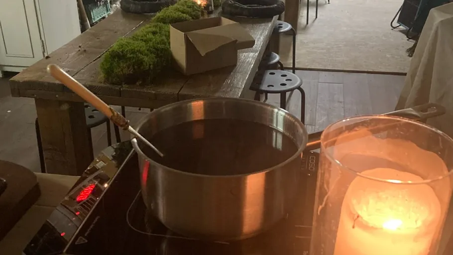 Pot on stove next to candle indoors.