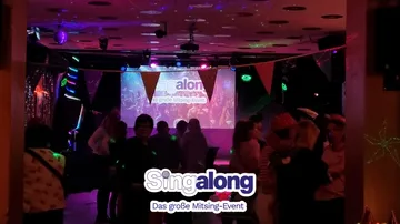 Menschen versammeln sich bei Karaoke-Event mit Dekoration.