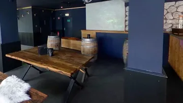 Wooden table in rustic bar setting.