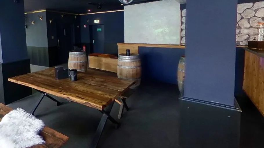 Wooden table in rustic bar setting.