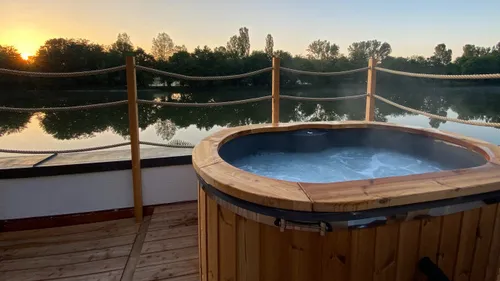 Whirlpool dampft auf einem Deck am See.